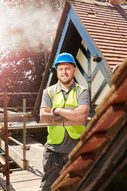 a builder or roofer is posing to camera on the roof of a renovation project